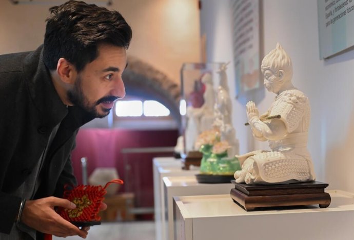 A man watches the Dehua white porcelain exhibit at Rafael Morales Culture Center in Talavera de la Reina, Spain, Nov. 11, 2025.