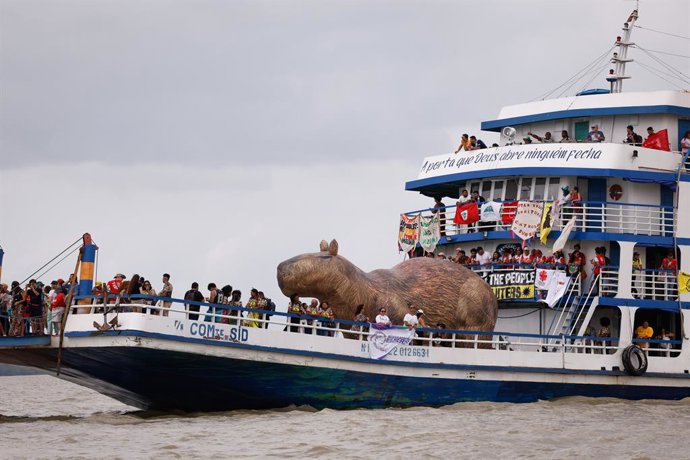 12 November 2025, Brazil, Belem: A giant capybara figure is on board a boat at a People's Summit event at Guajara Bay during the UN Climate Change Conference COP30 in Brazil. Photo: Tânia Rêgo/Agencia Brazil/dpa