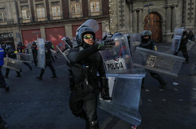 Police  during the  â€Gen Zâ€ demonstration  at main square Zocalo against the Mexican government following the murder of Uruapan Mayor Carlos Manzola, while Mexico's President, Claudia Sheinbaum, has questioned the legitimacy of the movement in recent d