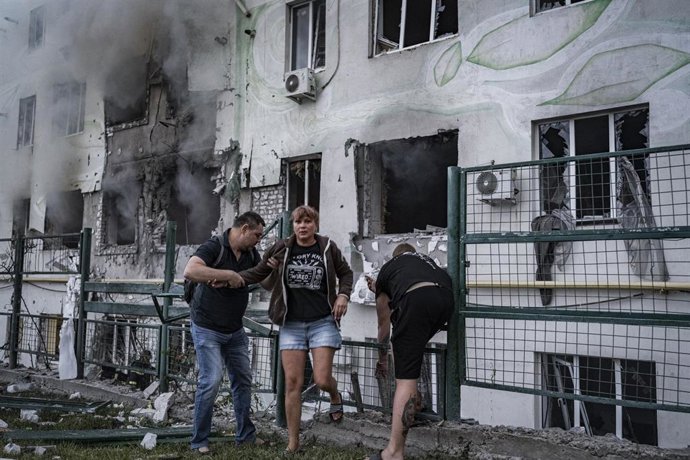 Archivo - Grupo de persona frente a un edificio residencial en Járkov atacado por el Ejército ruso