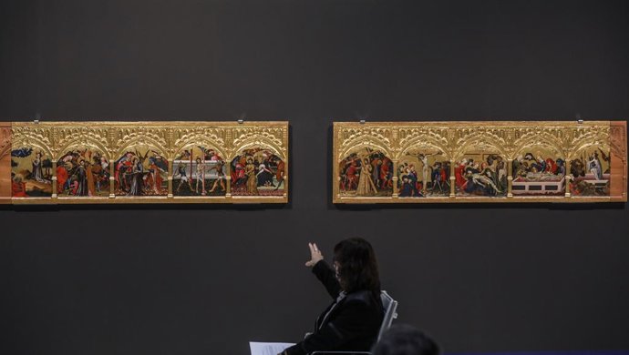 Archivo - Una mujer señala la restauración de la predela del Retablo de San Jorge del Centenar de la Ploma después de su presentación, en Valencia, Comunidad Valenciana (España). ARCHIVO. 