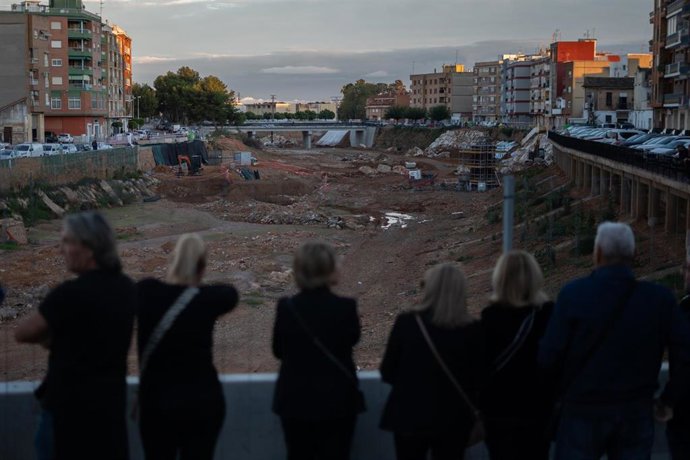 Varias personas hacen una cadena humana para homenajear a las víctimas de la dana, en la Rambla del Poyo, a 26 de octubre de 2025, en Paiporta, Valencia, Comunidad Valenciana (España).