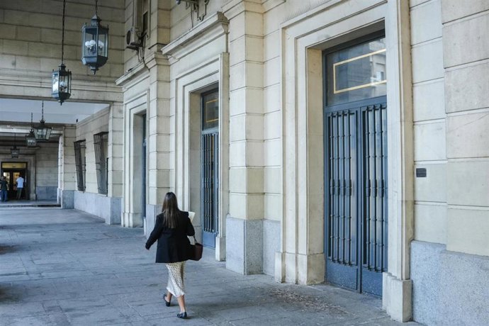 Una mujer camina hacia la Audiencia de Sevilla en imagen de archivo.