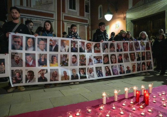 Archivo - Varias personas sostienen un cartel con imágenes de algunos fallecidos, durante una conmemoración por las víctimas de la dana en Valencia, en la Plaza de la Iglesia de Picanya, a 15 de febrero de 2025