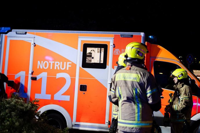 Archivo - Arquivo - 28 de setembro de 2025, Belrlin, Alemanha: Bombeiros se reúnem ao lado de uma ambulância marcada como "Notruf 112" durante uma resposta de emergência noturna em Berlim, Alemanha... Os serviços de emergência, incluindo polícia, bombeiro