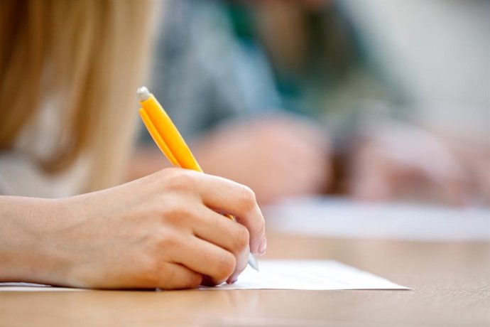 Archivo - Una persona escribe en un papel.
