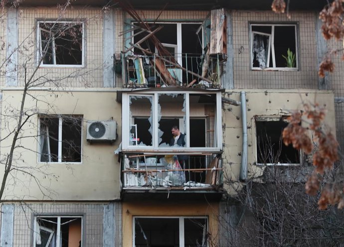 KIEV, 14 de novembro de 2025 -- Um homem limpa a varanda de um prédio residencial danificado após os ataques noturnos de drones e mísseis balísticos russos em Kiev, Ucrânia, em 14 de novembro de 2025.