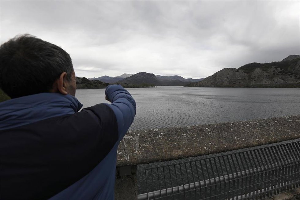 Archivo - Un hombre señala el embalse del río Porma, en León.