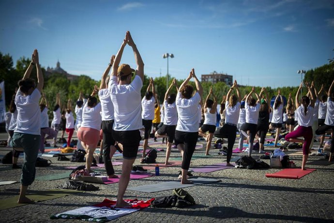 Archivo - Decenas de personas durante una master class de yoga.