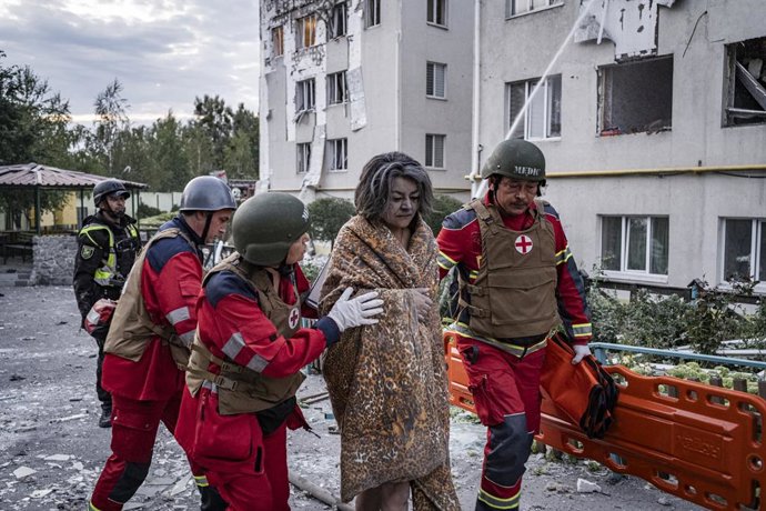 Archivo - Arquivo - 18 de agosto de 2025, Kharkiv, Oblast de Kharkiv, Ucrânia: Equipes de resgate ajudam um civil ferido a sair de um prédio residencial que foi atingido por um ataque de míssil russo. Às 5h da manhã, cinco drones Shahed atingiram um prédi