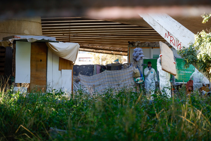 Técnicos del Ayuntamiento sacan material de la zona de asentamiento bajo el Puente de Calatrava del distrito barcelonés de Sant Martí