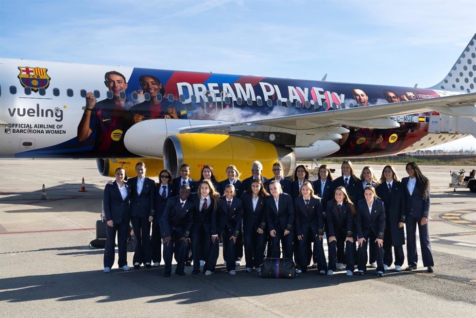 Las jugadoras del Bara Femení ante el avión que luce su imagen.