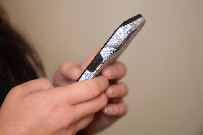 FILED - 22 October 2025, Saxony, Dresden: A woman types on a smartphone. More than 28,000 households in Germany still have no or little access to high-speed mobile internet, according to a new study released on Tuesday. Photo: Sebastian Kahnert/dpa