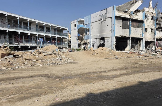 November 18, 2025, Khan Yunis, Gaza Strip, Palestinian Territory: Displaced Palestinians return to shelter inside destroyed school buildings east of Khan Younis, near the yellow demarcation line, after their tents along the coastline were flooded during t