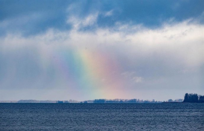 18 November 2025, Mecklenburg-Western Pomerania, Stralsund: Clouds and a rainbow move across the Strelasund off the island of Ruegen in Stralsund. Photo: Stefan Sauer/dpa