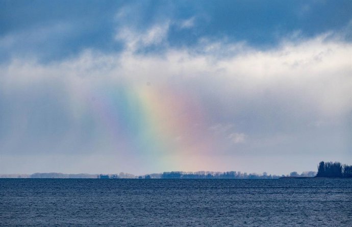 18 de novembro de 2025, Mecklenburg-Western Pomerania, Stralsund: Nuvens e um arco-íris se movem pelo Strelasund, na ilha de Ruegen, em Stralsund. Foto: Stefan Sauer/dpa