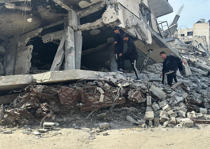 Archivo - Jóvenes palestinos sobre los escombros de casas destruidas en Jan Yunis, en el sur de la Franja de Gaza