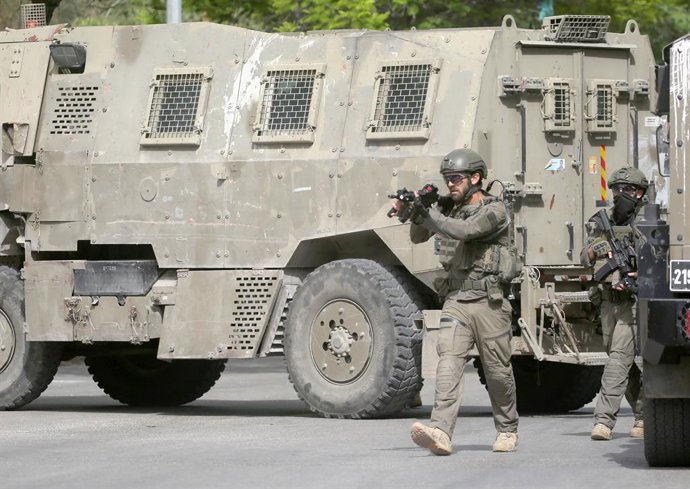 Archivo - 18 May 2025, Palestinian Territories, Nablus: An Israeli soldier fires a shot into the air during a military operation in Balata village. Israeli forces raid a house and arrest a Palestinian wanted by the Palestinian Authority. Photo: Nasser Ish