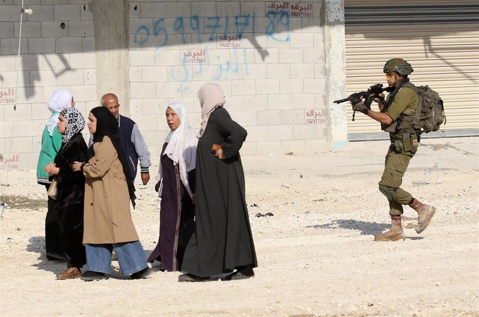 Un soldado israelí apunta a un grupo de mujeres palestinas en el campo de refugiados de Nur Shams, en la ciudad cisjordana de Tulkarem