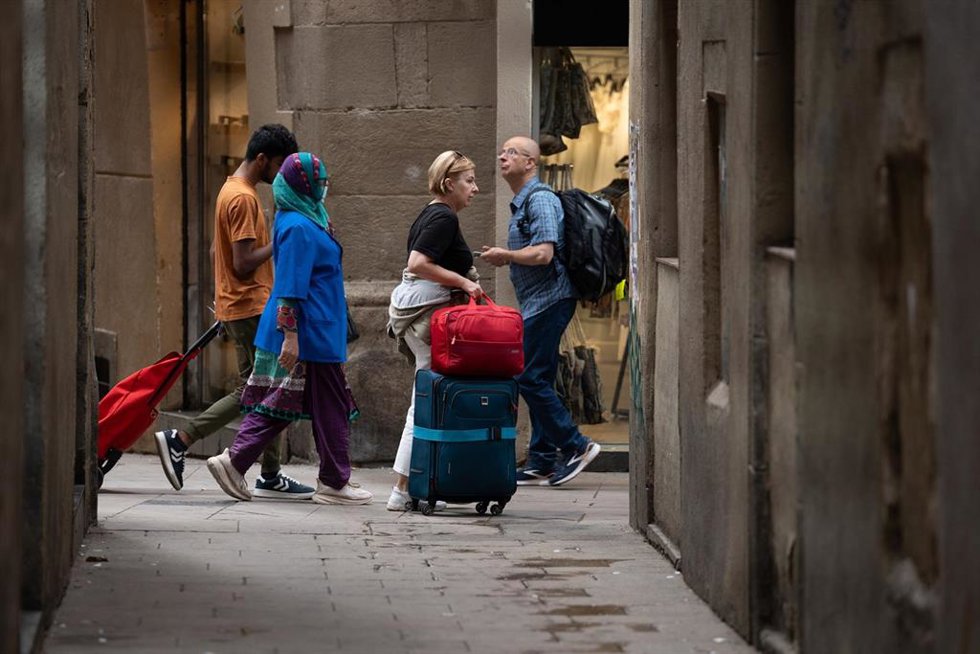 Archivo - Varios turistas con maletas en el centro de Barcelona.