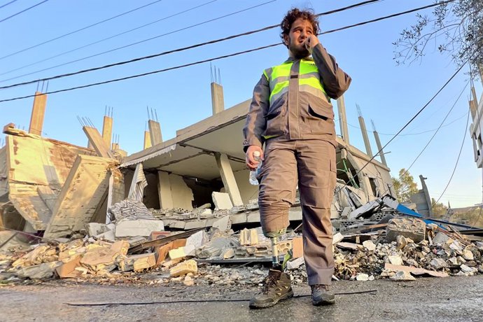 DEIR KIFA, 20 de novembro de 2025 -- Um trabalhador médico com um membro protético fica em frente às ruínas de um prédio destruído por ataques aéreos israelenses em Deir Kifa, no sul do Líbano, em 19 de novembro de 2025: 1053442814, Licença: Rights-manage