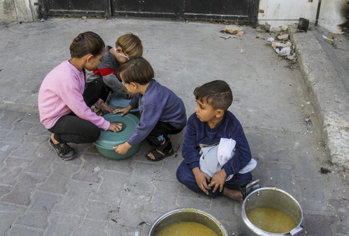 Archivo - Arquivo - 23 de outubro de 2024, Gaza, Faixa de Gaza, Palestina: Crianças palestinas deslocadas internamente são vistas com alimentos distribuídos a elas por organizações de caridade no distrito de Nasser, na Cidade de Gaza. A crise alimentar em