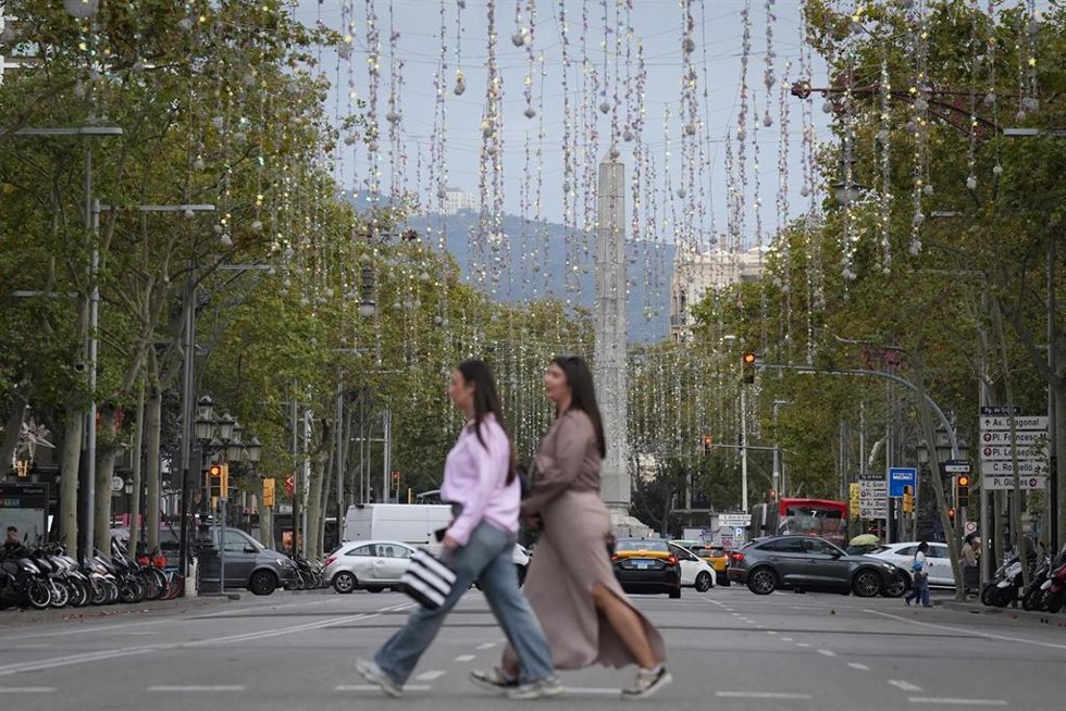 Archivo - Una persona pasa por el Paseo de Gracia, con las luces de Navidad recién colocadas, en una imagen de archivo.