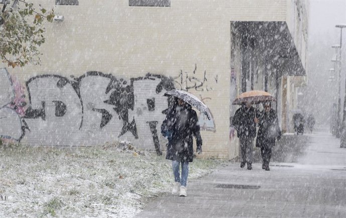 Paseantes cubiertos de nieve durante la llegada de una masa de aire ártico, a 21 de noviembre de 2025, en Vitoria, País Vasco (España).