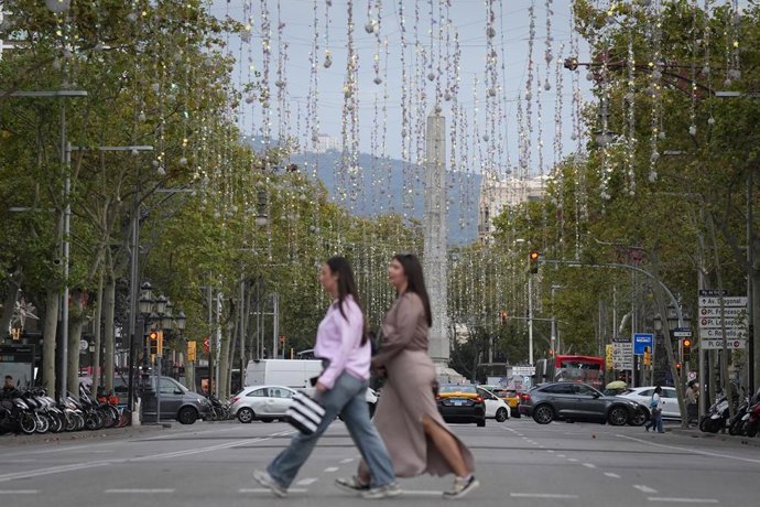 Archivo - Arxivo - Una persona passa pel Passeig de Gracia, amb les llums de Nadal recentment col·locades, en una imatge d'arxiu.