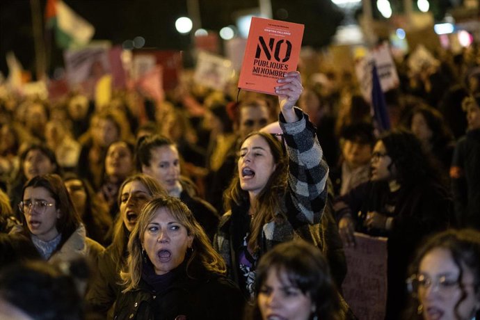 Archivo - Una mujer levanta un libro durante la manifestación organizada por la Comisión 8M con motivo del 25N y bajo el lema "Juntas, el miedo cambia de bando".
