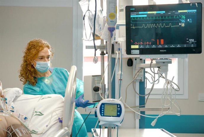 Una sanitaria proporciona cuidados de enfermería a un paciente ingresado.