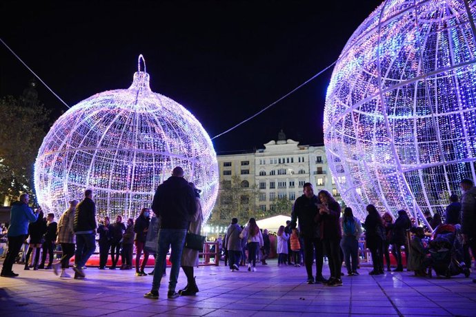 Archivo - Un grupo de personas en el acto de encendido de la iluminación navideña de la plaza del Ayuntamiento