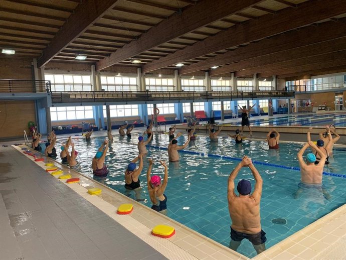 Usuarios de uno de los programas municipales en las piscinas cubiertas de Alcalá.