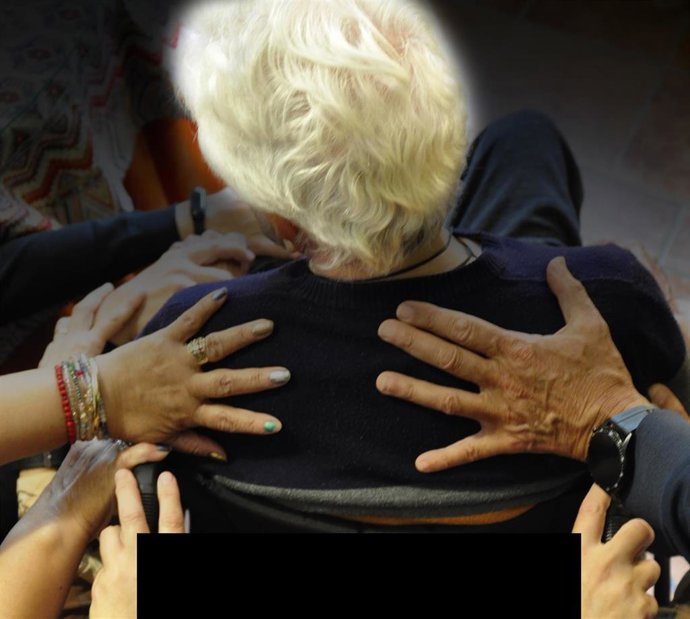 Archivo - Unas personas ayudan a una mujer mayor.