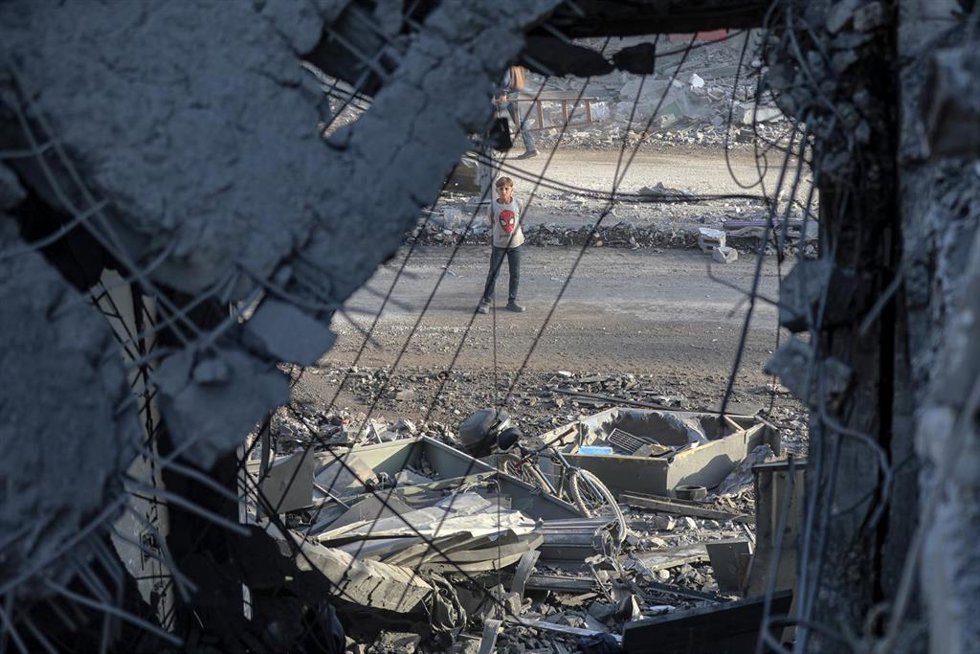 Un niño palestino frente a un edificio alcanzado en un bombardeo de Israel contra el barrio de Al Zeitún, en la ciudad de Gaza, situada en el norte de la Franja, a pesar del alto el fuego en vigor desde el 10 de octubre (archivo)