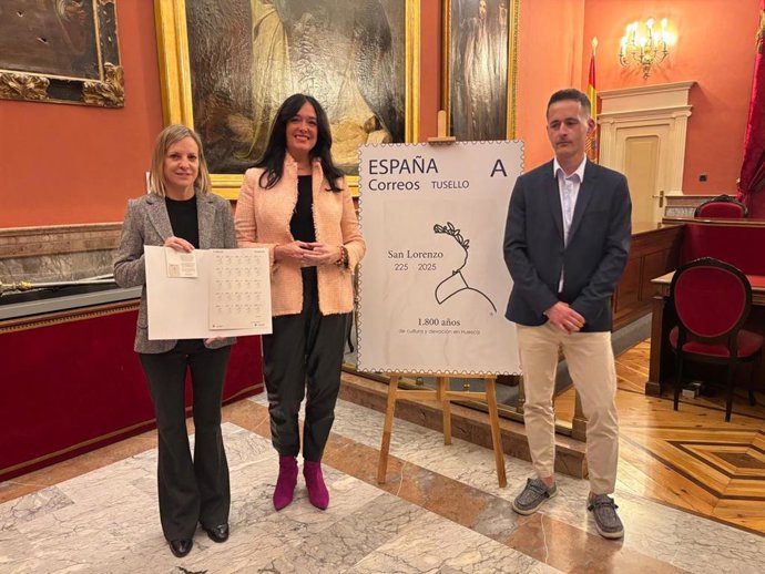 La alcaldesa de Huesca, Lorena Orduna; la concejal, Nuria Mur; y el director de la oficina de Correos de Huesca, Miguel Trallero, en la presentación del sello conmemorativo del 1.800 aniversario del nacimiento de San Lorenzo.