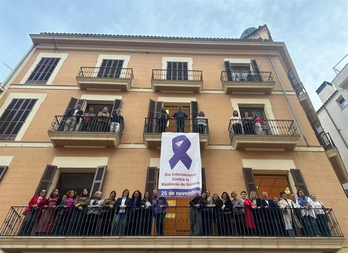 Cargos institucionales y orgánicos socialistas despliegan en la fachada de la sede del PSIB-PSOE la lona en apoyo al movimiento feminista para el 25N