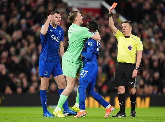 24 November 2025, United Kingdom, Manchester: Everton's Idrissa Gueye is held back by Jordan Pickford after a confrontation with team mate Michael Keane, leading to a red card during the English Premier League soccer match between Manchester United and Ev