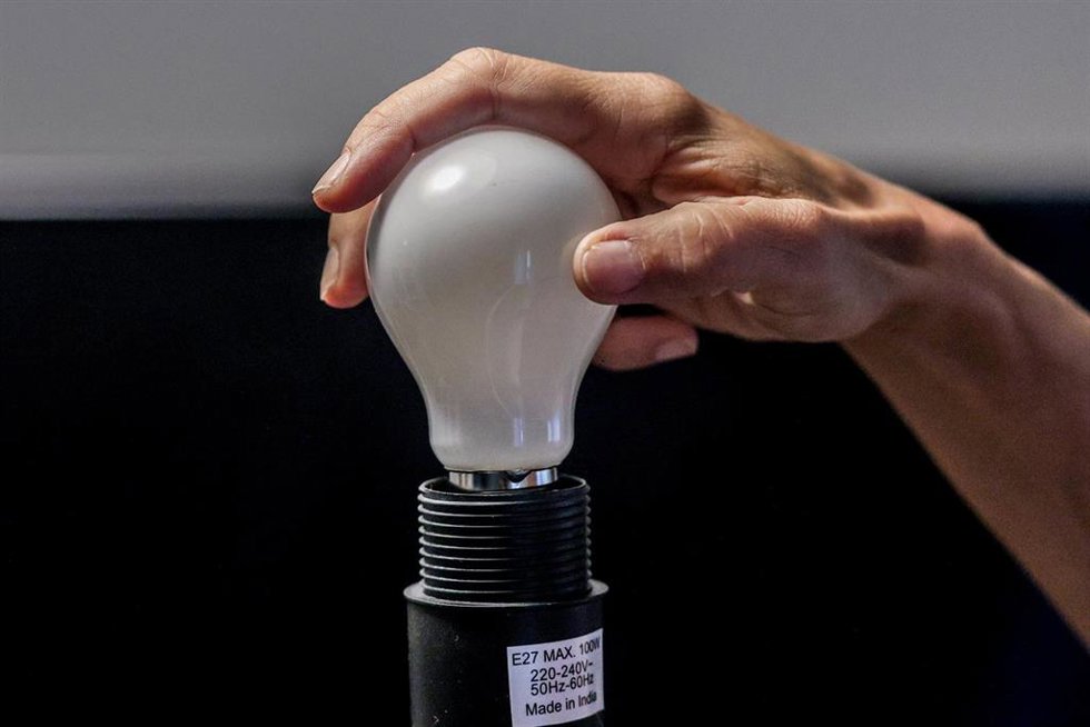 Archivo - Una persona enrosca una bombilla, a 8 de septiembre de 2024, en Madrid (España). El precio medio de la electricidad en el mercado mayorista ha caido este domingo, 8 de septiembre, un 14,2% con respecto al sábado, hasta situarse en los 67,76 eu
