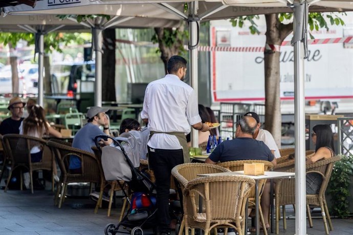 Archivo - Clientes de un bar se refrescan en la terraza, a 15 de julio de 2025, en Madrid (España).