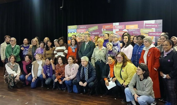 Acción colectiva en Bilbao con motivo del 25N. Los participantes posan junto al mural con diversas palabras que han ido formando en el Teatro Campos Elíseos.