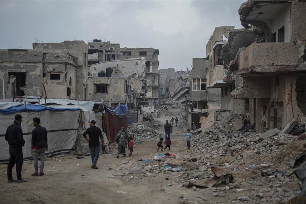 Palestinos en el campamento de refugiados de Shati entre edificios dañados por la ofensiva de Israel contra la Franja de Gaza (archivo)