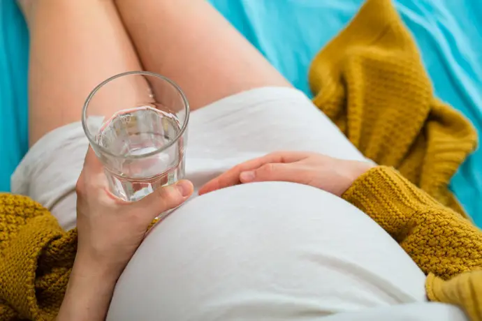 Embarazada sostiene un vaso de agua. - GETTY IMAGES/ISTOCKPHOTO / DEJAN DUNDJERSKI