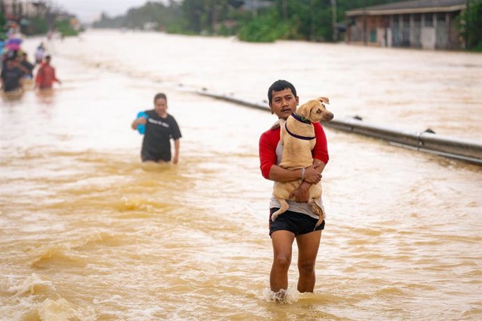 Un grupo de personas vadean una zona inundada en Hat Yai, en la provincia de Songkhla, en el sur de Tailandia (archivo)