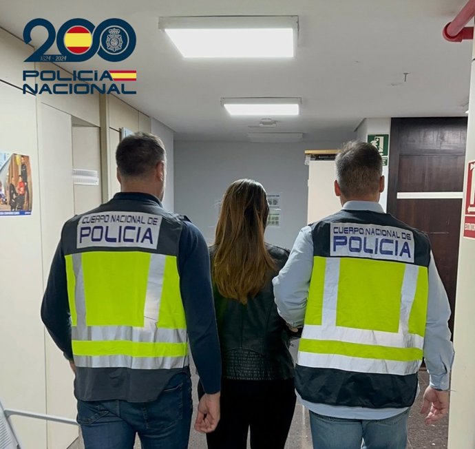 La detenida, de espaldas, junto a dos agentes de la Policía Nacional.