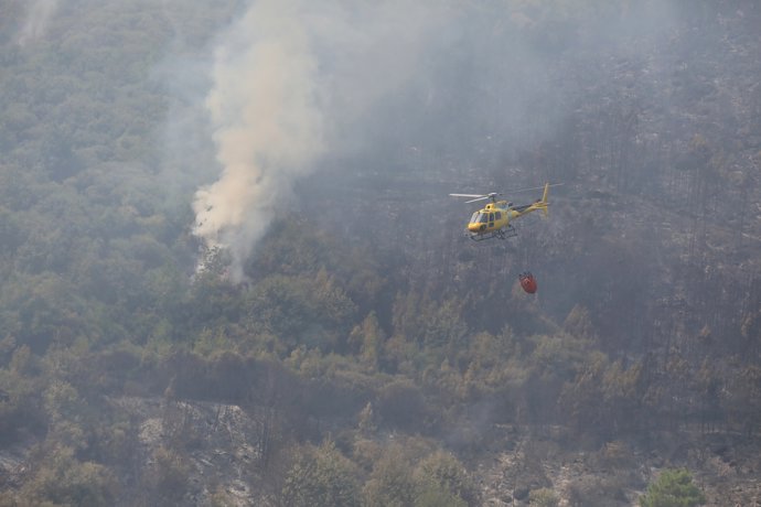 Un helicoptero tira agua sobre la zona del incendio, a 31 de julio de 2025, en Cuevas del Valle, Ávila, Castilla y León (España). Actualmente hay tres puntos de llama activa donde se está intentando controlar el fuego con una gran cantidad de efectivos.