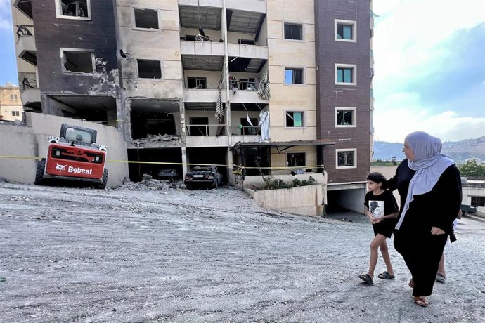 Archivo - Una mujer y su hija pasan frente a un edificio atacado por Israel en Nabatié, en el sur de Líbano