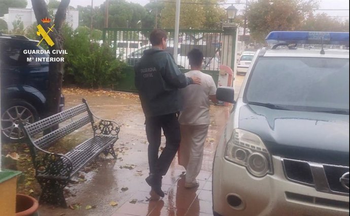 Un agente de la Guardia Civil lleva detenido al supuesto cabecilla de la trama.