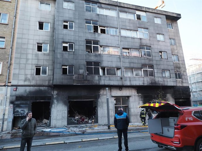 Efectivos de Bomberos trabajan en el lugar del incendio que ha afectado a un bazar y ha obligado a desalojar varias viviendas en la avenida Marcelo Celayeta de Pamplona.