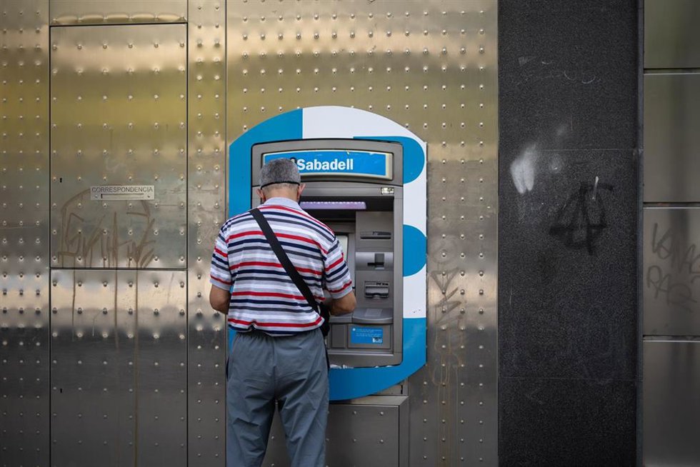 Archivo - Un hombre saca dinero en un cajero de Sabadell, a 6 de junio de 2024, en Madrid (España). 